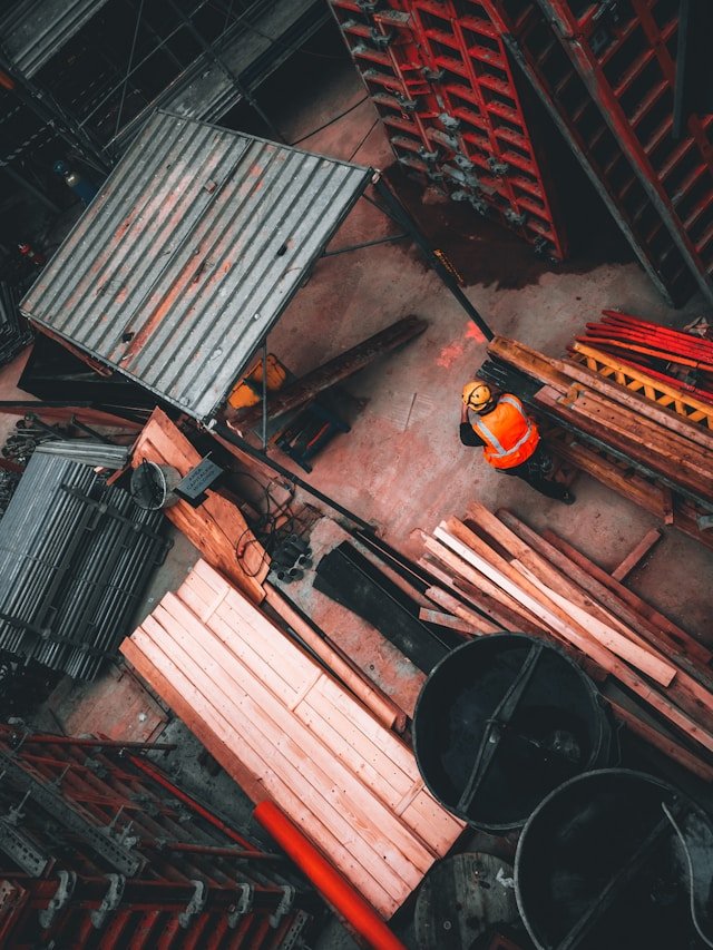 High-angle view of a construction site with structural formwork, timber materials, and a site-supervised worker, illustrating Smart Agnes’s comprehensive civil works and fit-out services in Qatar.