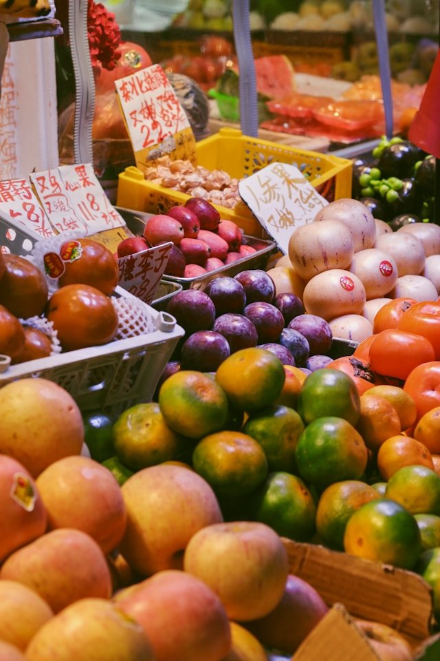 A vibrant display of premium fresh fruits including apples, citrus, and seasonal exotics in a market setting, representing Smart Agnes’s bulk supply services for retailers and hotels in Qatar.