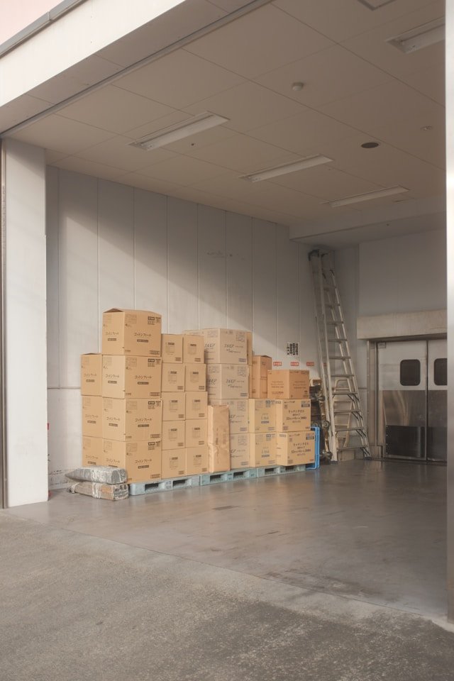 Neatly stacked cargo boxes on pallets within a clean, professional loading bay, representing Smart Agnes’s organized logistics and strict quality guarantee for goods handled in Qatar.